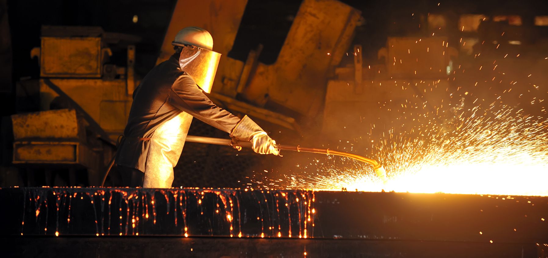 worker using torch cutter to cut through metal